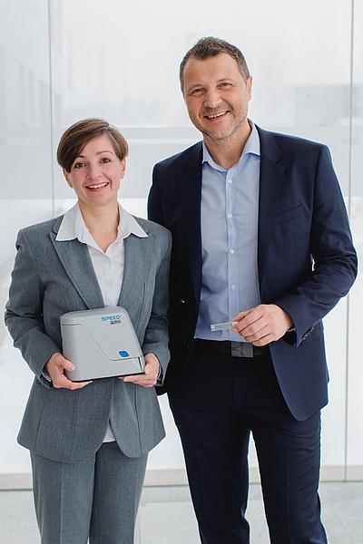Dr. Sonja Kierstein (CTO) and Dr. Max Sonnleitner (CEO) with the compact GENSPEED® Point of Care Testing technology. © Indrich Fotografie