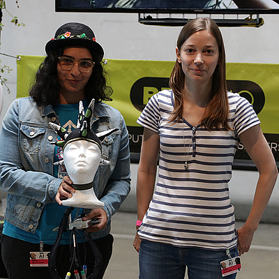 Zwei Mädchen stehen nebeneinander und halten das Siegerprojekt in die Kamera