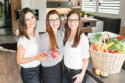 Teambild von 3 Damen mit Obst & Gemüse in den Händen